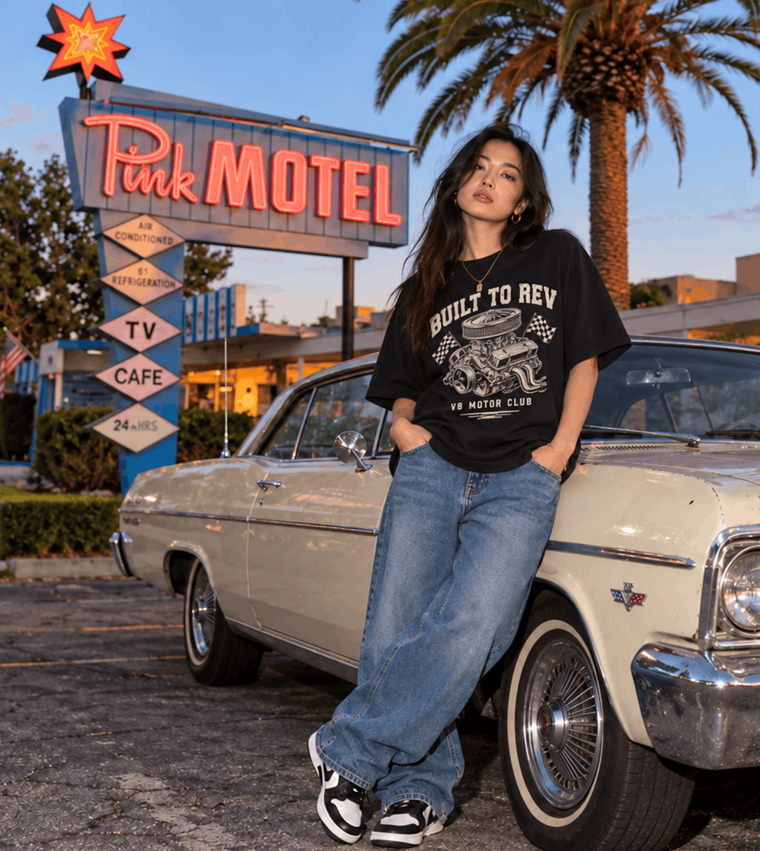 Model wearing a black graphic tee beside a classic car in Sun Valley